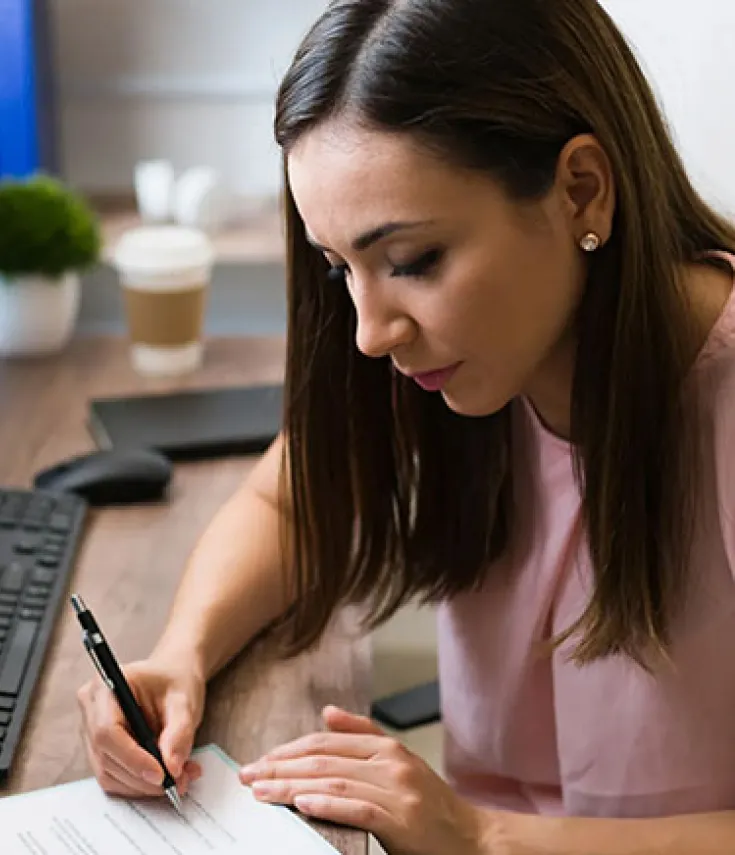 estudiante ucam analista de datos revisando métricas y gráficos en doble pantalla mientras toma notas