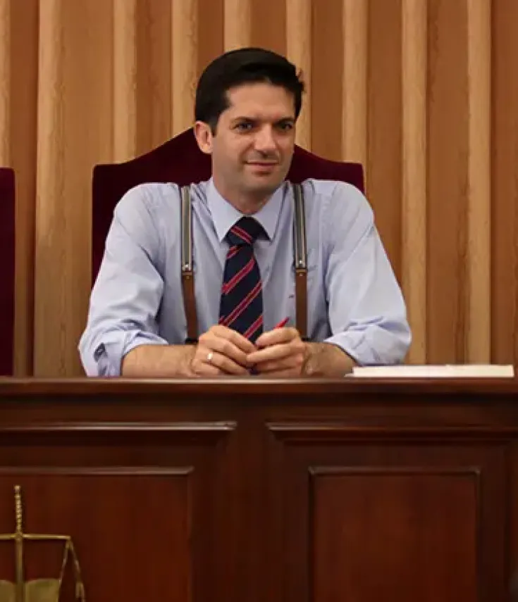 Profesor del Grado en Derecho de la UCAM dirige un simulacro de juicio en el aula ante sus estudiantes, reflejando la formación práctica y la implicación docente del Campus de Murcia.