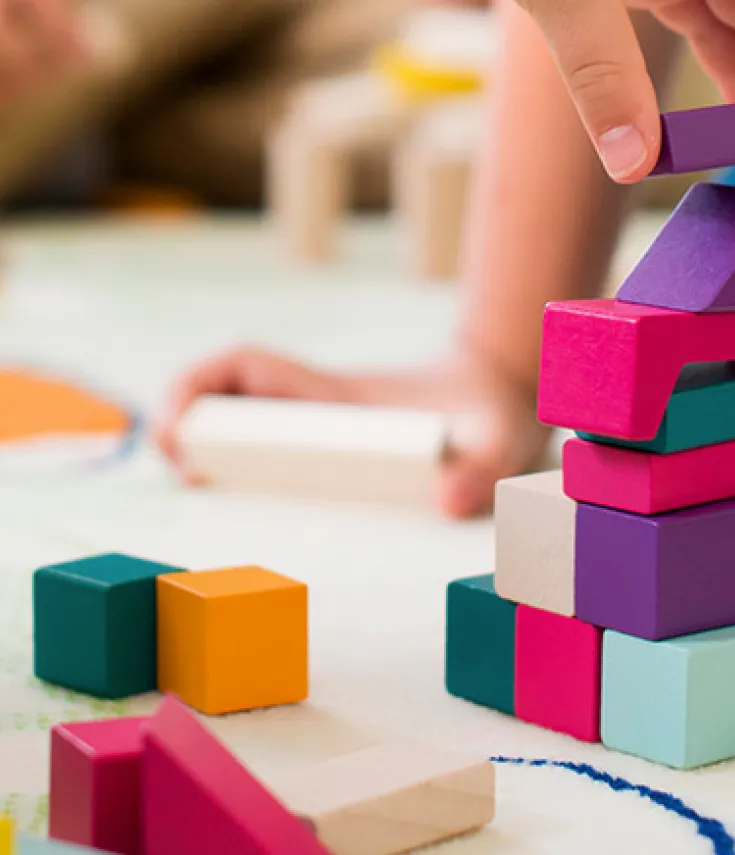 Alumnos de Educación Infantil explorando la bola del mundo en clase, fomentando la curiosidad y el aprendizaje global en la carrera de Magisterio Infantil.