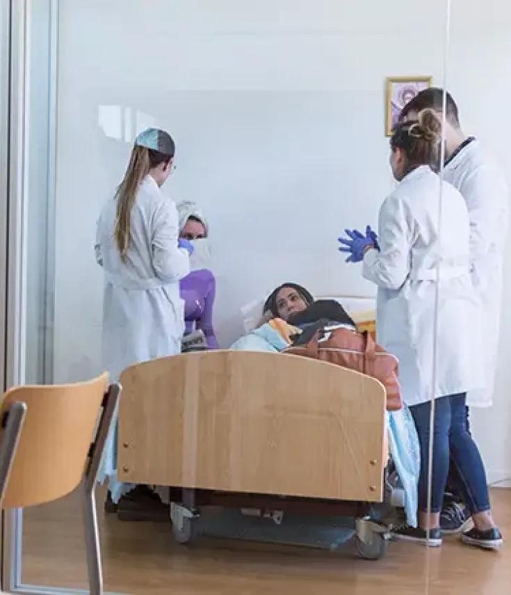 Estudiantes del grado en terapia ocupacional en el aula simulada del hogar, aprendiendo cómo ayudar a una paciente en su adaptación al día a día.