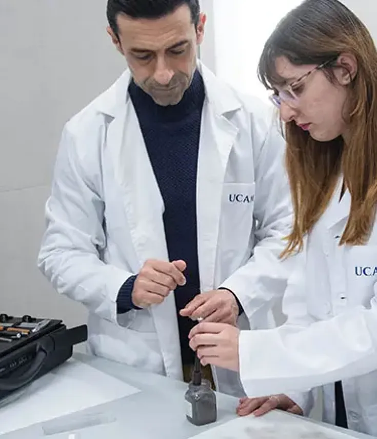 Profesor y estudiantes del Grado en Criminología de la UCAM realizan una práctica de análisis de huellas dactilares en el laboratorio del Campus de Murcia, destacando la formación aplicada y científica del programa semipresencial.