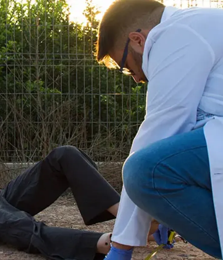 Estudiante del Grado en Criminología de la UCAM analiza una escena del crimen simulada en el Campus de Murcia, mostrando el enfoque práctico y la formación aplicada del programa semipresencial.