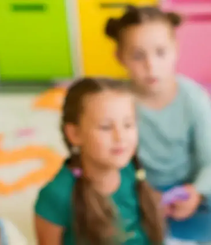Niños de Educación Infantil desarrollando su creatividad al pintar un mural con las manos, reflejo de la formación en el grado de Magisterio y pedagogía infantil.