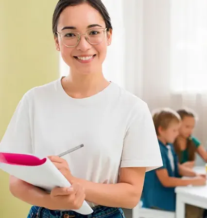 Maestra de Educación Infantil apoyando de manera personalizada a una niña durante una actividad en el aula.