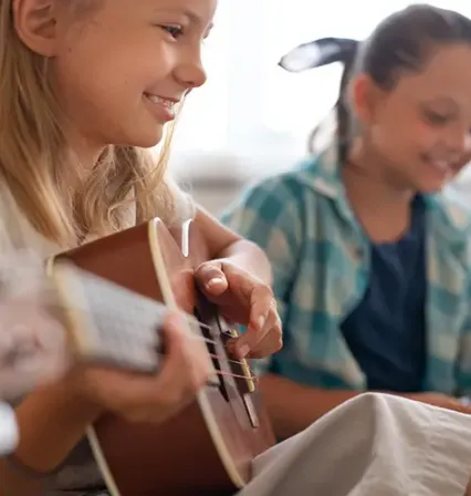 Niños de educación primaria participando activamente en el aula de música, ejemplo de las metodologías innovadoras que se aplican al estudiar Magisterio Primaria.