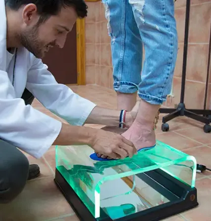 Podólogo de la UCAM explicando a sus estudiantes del grado en podología cómo realizar un estudio de la pisada.