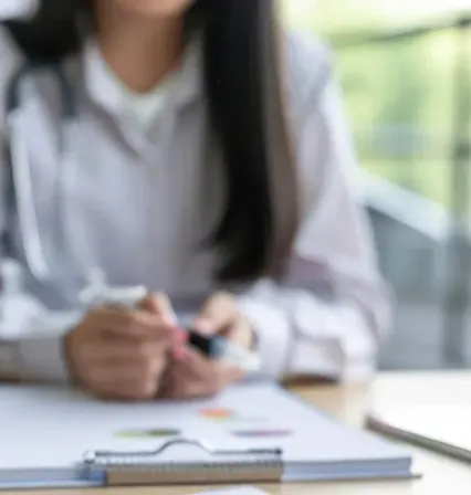 Psicóloga clínica tomando notas durante una sesión de terapia con una paciente