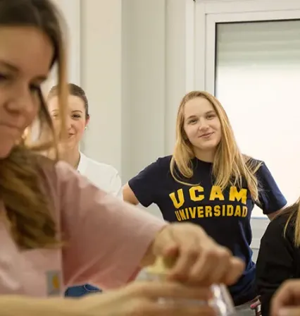 Estudiantes de terapia ocupacional de la UCAM en sus prácticas en una residencia de ancianos ayudando a los pacientes a mejorar su movilidad con ejercicios adaptados a su edad.