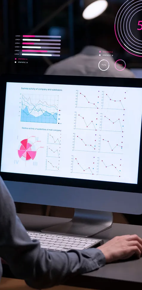 Una profesional con auriculares trabaja en su ordenador analizando gráficos estadísticos, diagramas de sectores y dashboards con métricas sobre un fondo oscuro con gráficos digitales flotantes de Big Data.