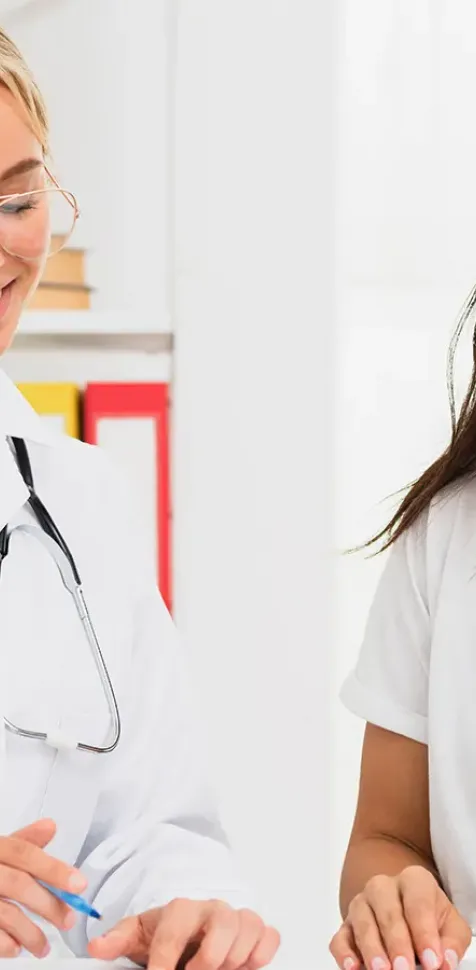 Dietista-nutricionista atiende a una paciente en consulta, diseñando un plan alimentario personalizado, reflejando la formación práctica y el enfoque en salud y bienestar del Grado en Nutrición Humana y Dietética de la UCAM.