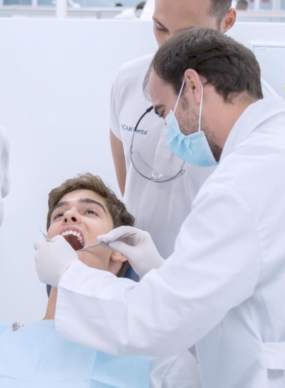 Un dentista observando la boca de un chico joven