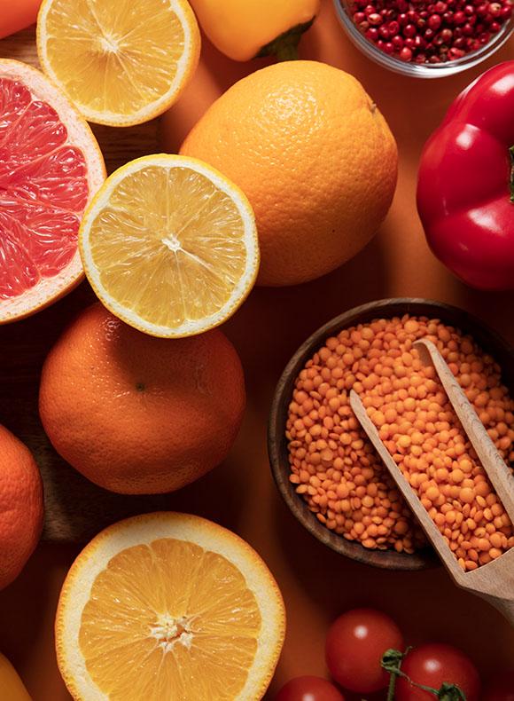 Variedad de alimentos ricos en antioxidantes, como cítricos, lentejas y verduras frescas, utilizados para ilustrar contenidos sobre nutrición, salud y estrés oxidativo.