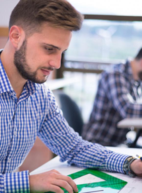 chico dibujando un plano con diferentes reglas
