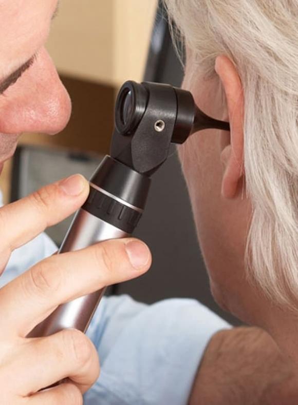 Médico con otoscopio