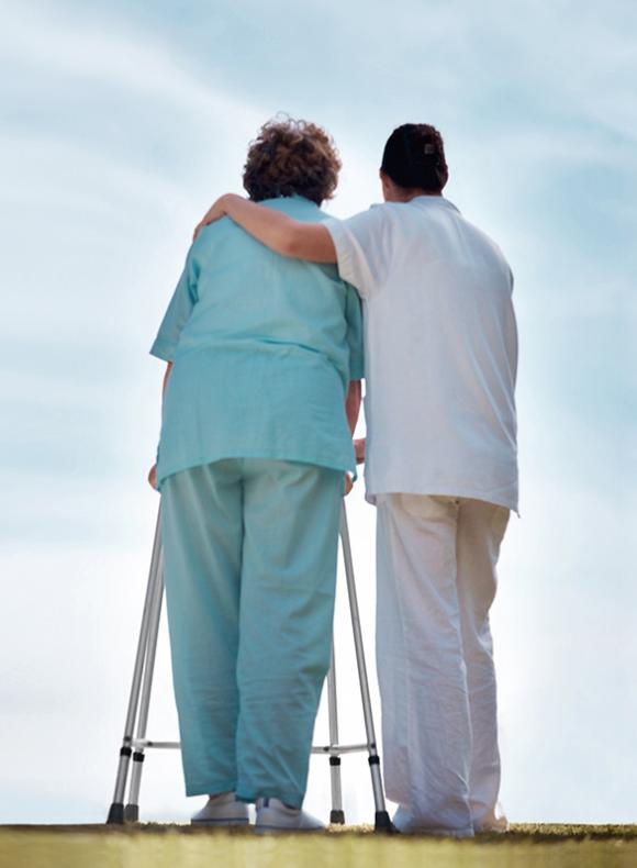 Enfermera ayudando a una mujer mayor a caminar