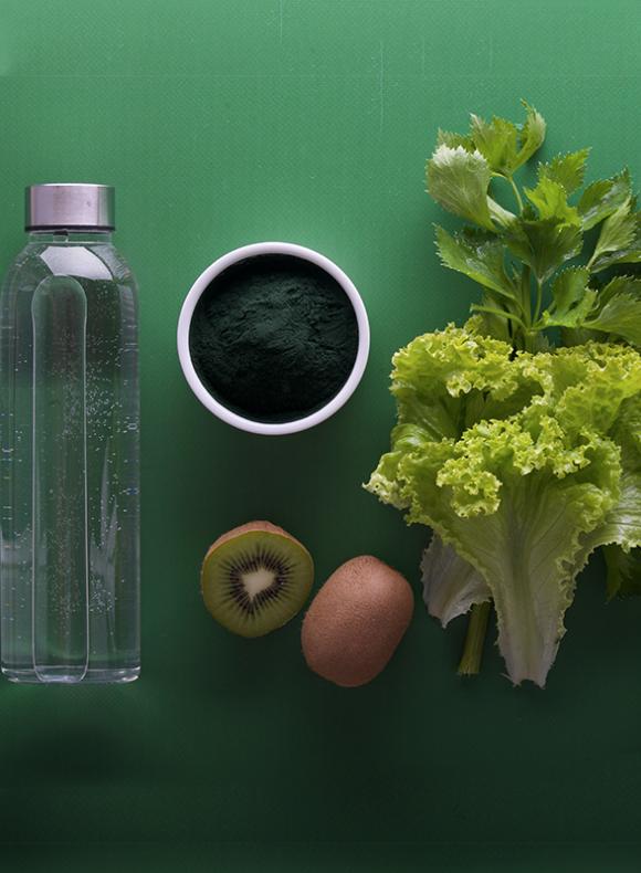 Botella de agua, hojas de lechuga y kiwis
