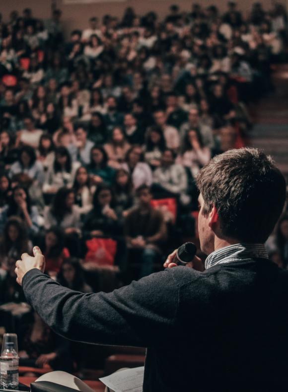 Hombre hablando a mucha gente