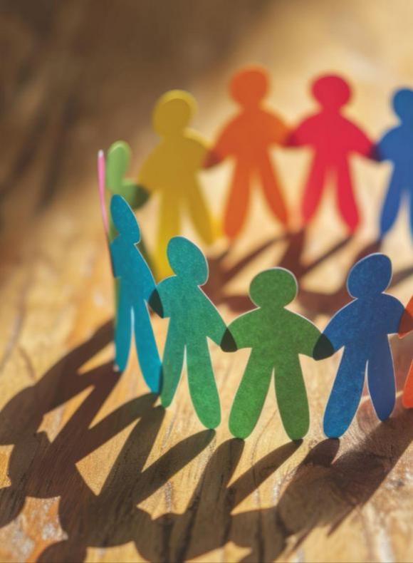 Figuras de papel de colores unidas en círculo como símbolo de integración social en la UCAM.