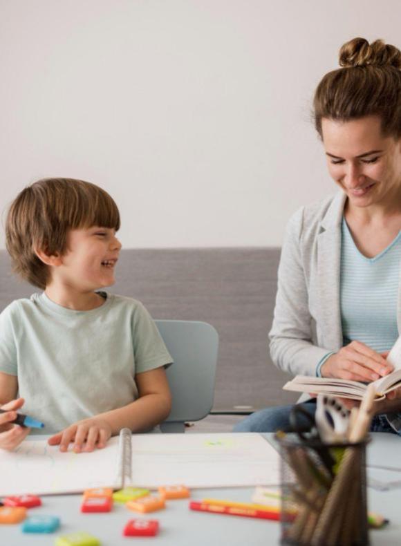 alumno aprendiendo a leer con una profesora ucam