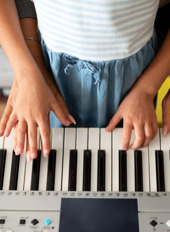 Niño tocando el piano en una clase de la UCAM