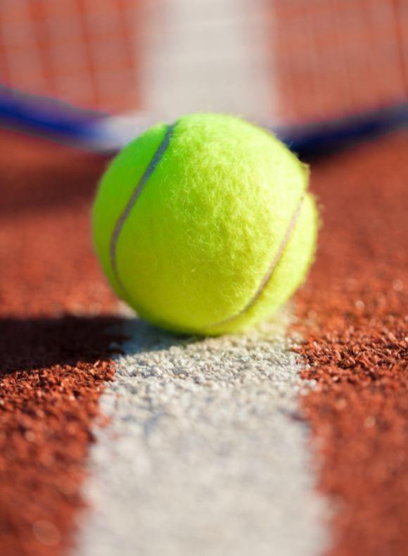 Pelota de tenis en una pista donde los alumnos UCAM están practicando. 