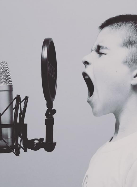 Niño gritando frente a un micrófono