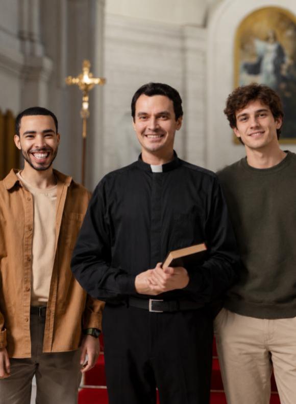 Servicio de Capellanía de la UCAM: sacerdote con Biblia acompañado por jóvenes universitarios