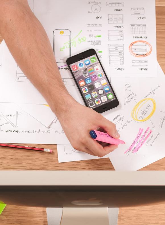 Hombre subrayando apuntes frente a un ordenador