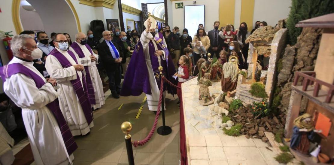 El obispo bendice el belén instalado en el claustro del Monasterio de Los Jerónimos.