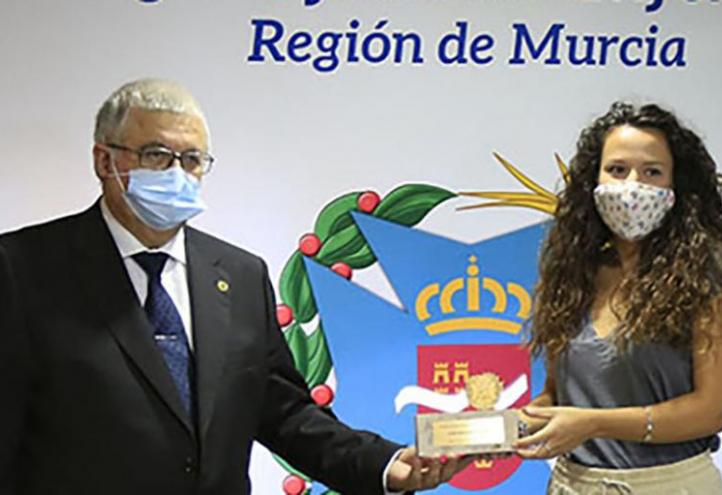 Judit Sánchez, egresada del Máster en Enfermería de Urgencias, Emergencias y Cuidados Especiales de la Universidad Católica, recibe el premio de manos de Manuel García Sánchez, presidente del Colegio de Enfermería de la Región de Murcia