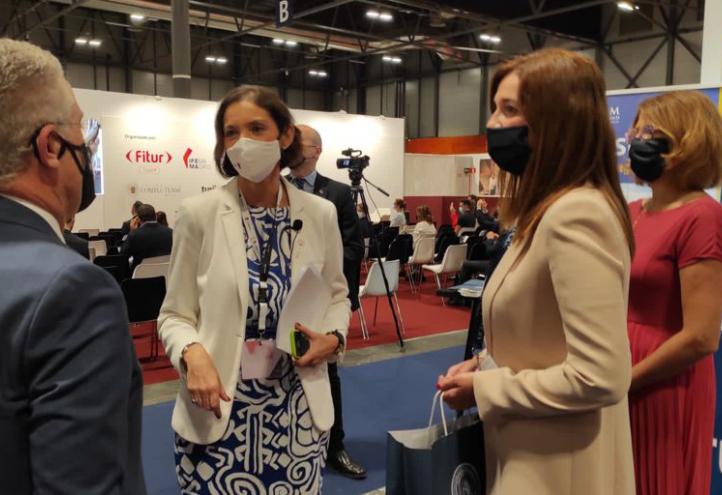 Reyes Maroto, ministra de Industria, Comercio y Turismo, durante su visita al &#039;stand&#039; de la UCAM conversa con Ginesa Martínez, vicedecana del Grado en Turismo