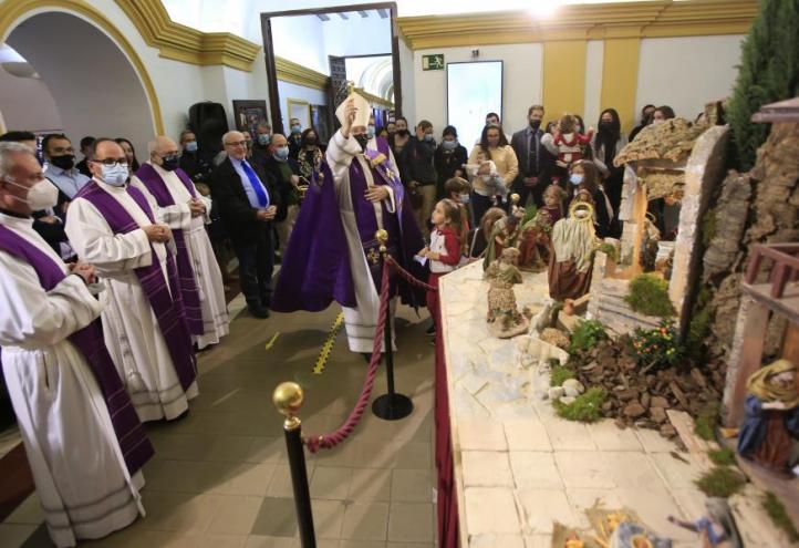 El obispo bendice el belén instalado en el claustro del Monasterio de Los Jerónimos.