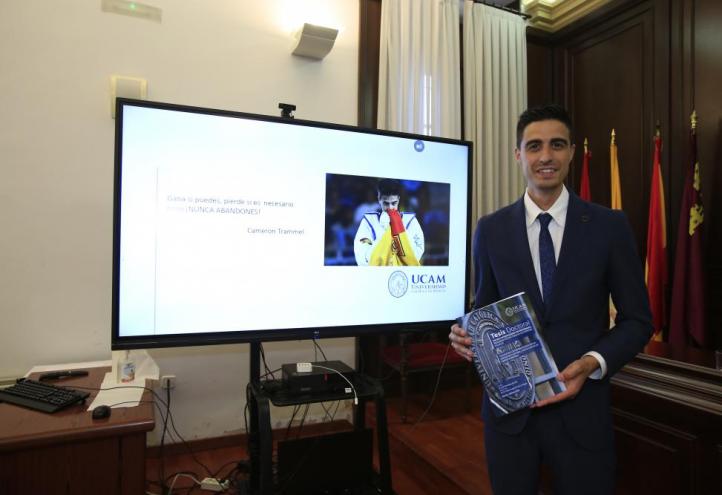 El campeón olímpico y mundial de taekwondo, Joel González, posa con su tesis tras doctorarse por la UCAM.