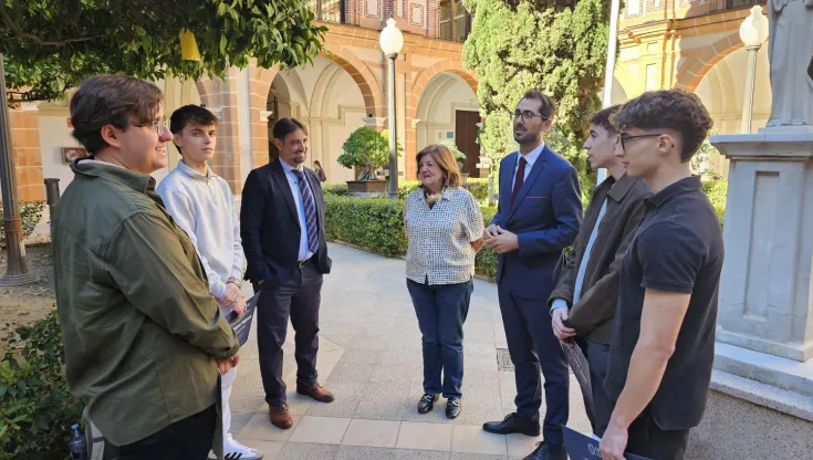 Los cuatro estudiantes de la UCAM conversando con María Dolores García, presidenta de la Universidad, Samuel Mendoza, director general de Infraestructuras y Desarrollo Digital, y Juan Francisco Hernández, secretario de la Facultad de Ciencias Sociales y de la Comunicación.